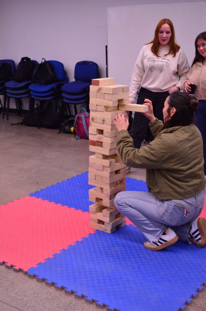 Estudiante y compañeros en una partida de Jenga durante la Juntita Civil
